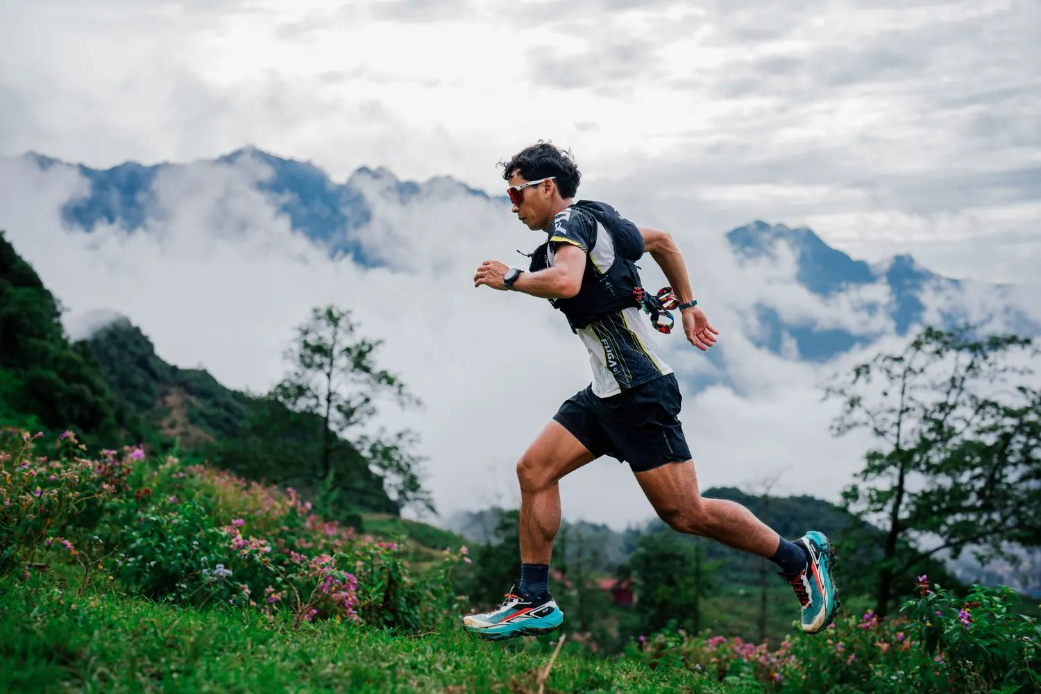 Un coureur en pleine foulée sur un sentier, au milieu des nuages.